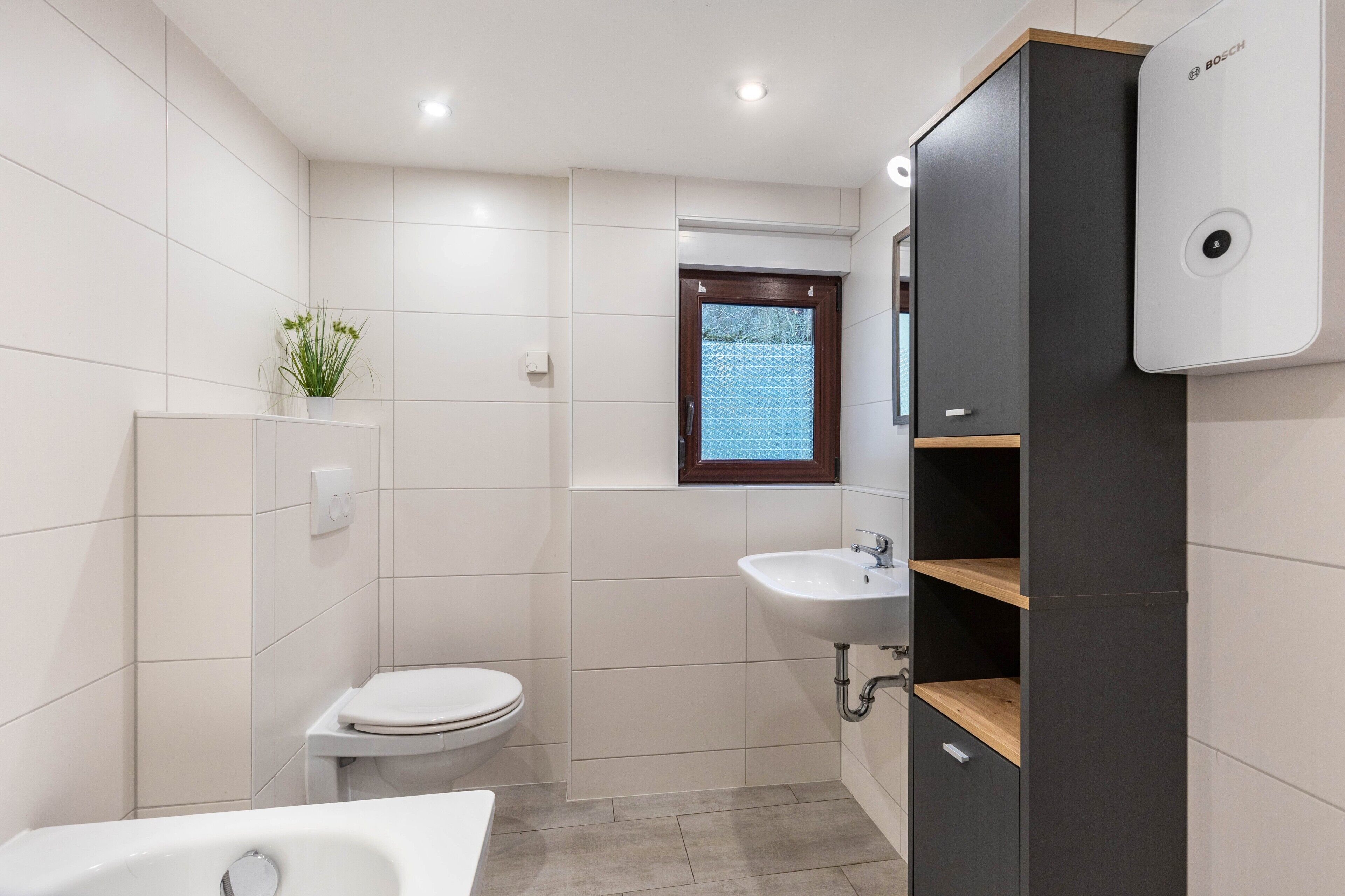 Un bagno moderno con toilette, lavabo e vasca da bagno.