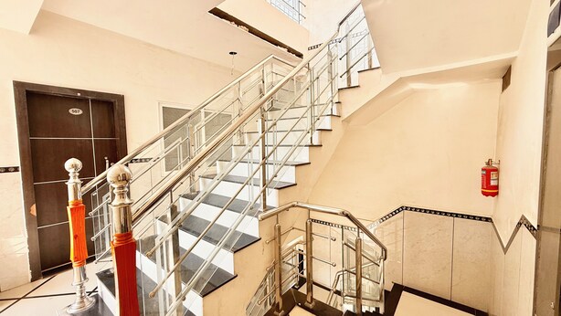 Un intérieur moderne avec un escalier en verre, un extincteur et une porte portant le numéro 507.