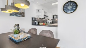 A modern dining area with a dark wooden table, a decorative tray, and a potted plant. - Portus - Sea view, balcony, barbecue, walk-in shower, fireplace (Olpenitz)