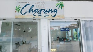 Un espace d’accueil avec une enseigne indiquant : « Charung by The Sea ».