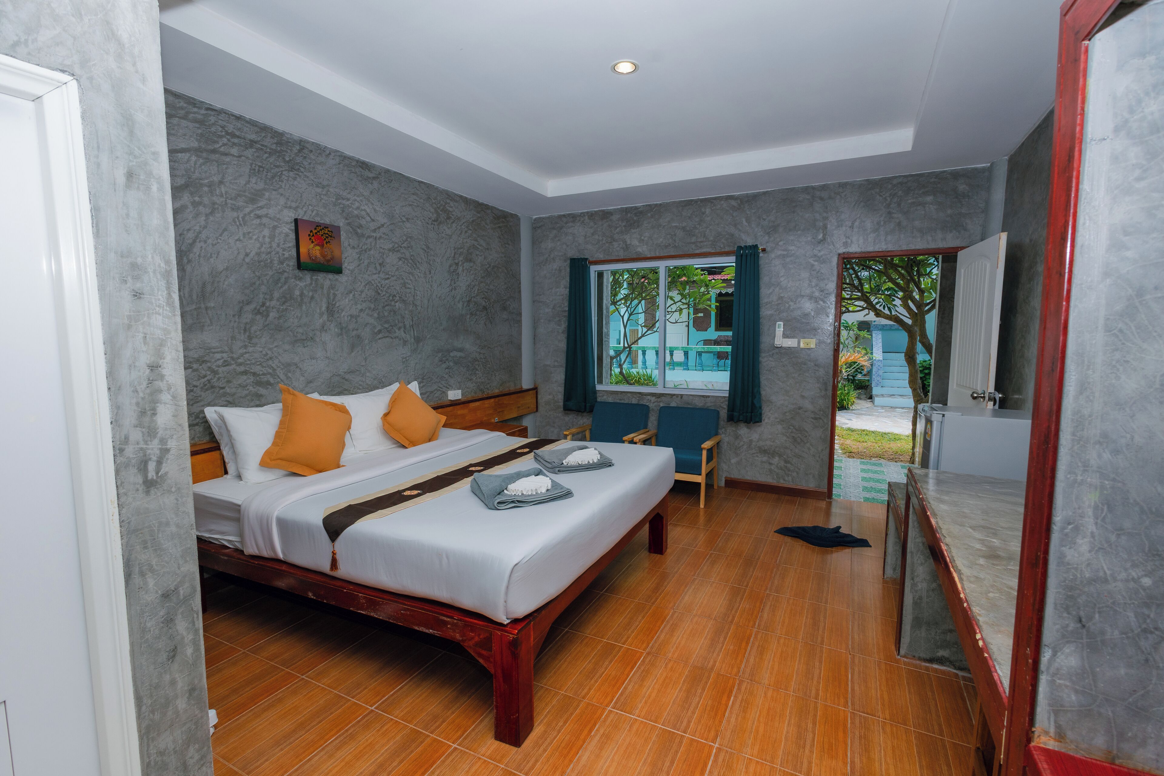 A hotel room with a bed, a desk, and a window with curtains.