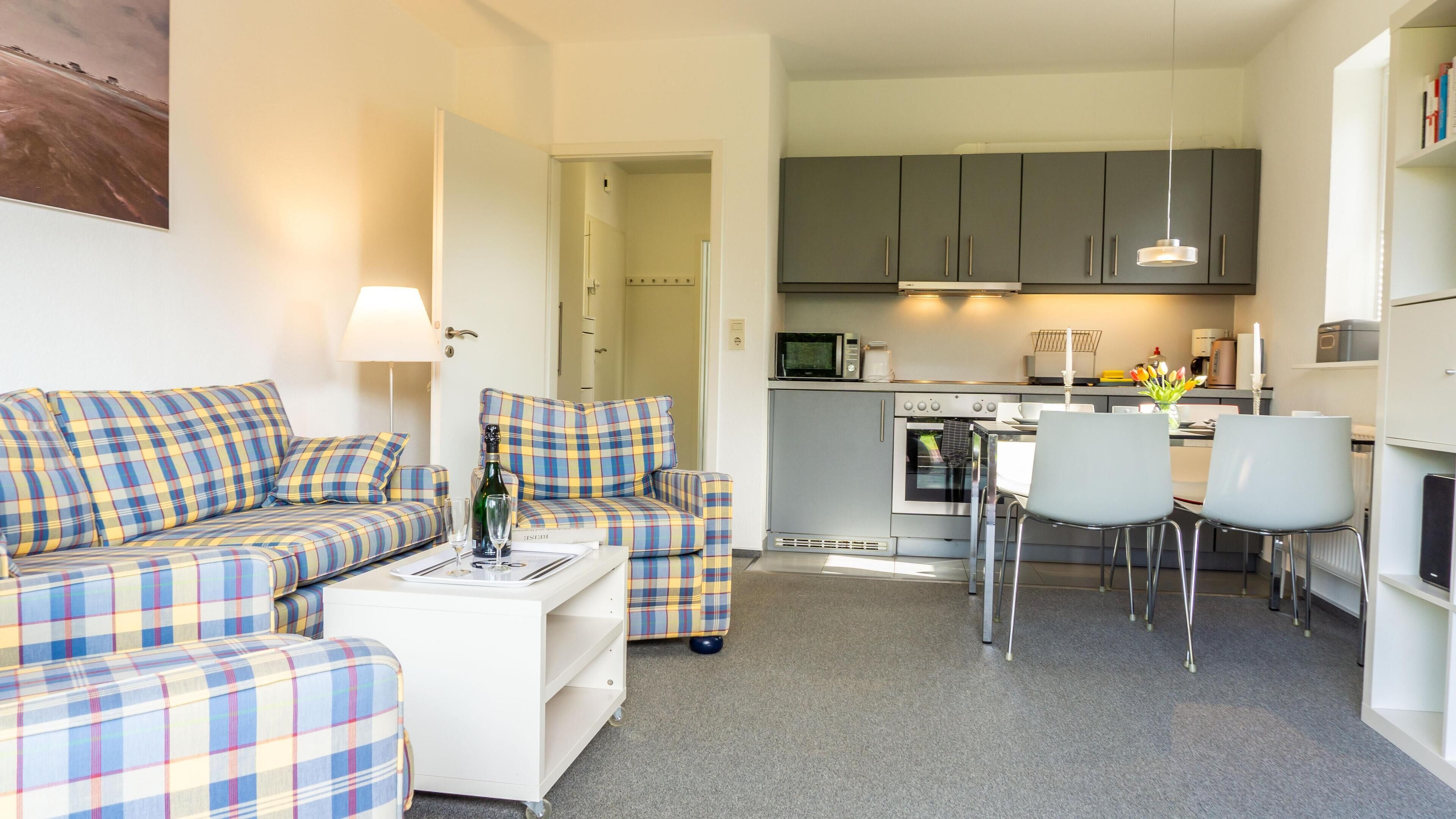 Ein modernes Wohnzimmer mit Sofa, Couchtisch und Essbereich mit Stühlen.