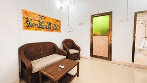 Ein Wohnzimmer mit einer Couch, einem Sessel, einem Couchtisch und einem Bild an der Wand.