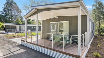 Casa móvel térrea com varanda coberta, um pequeno pátio e área externa cercada.