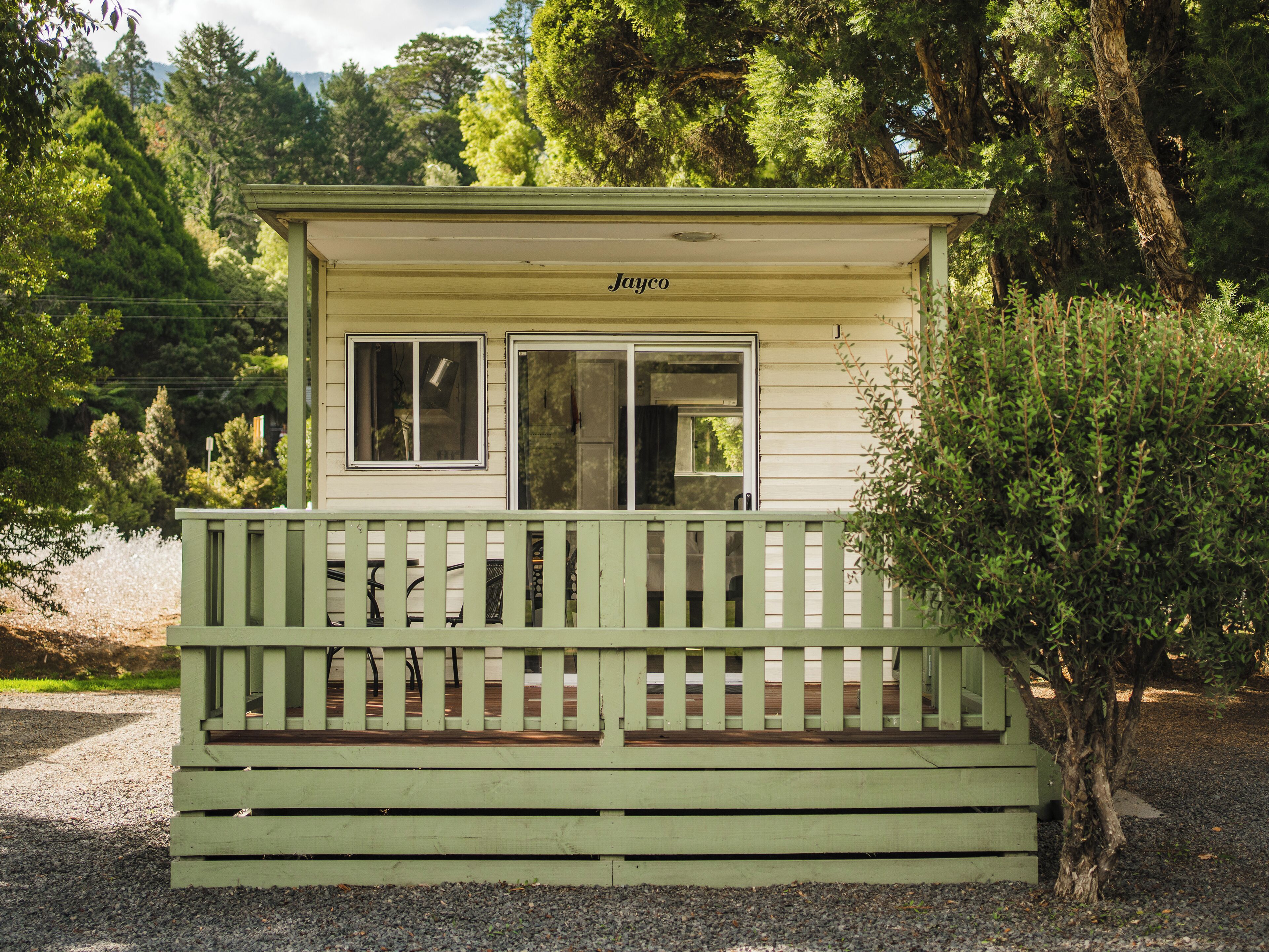 Een klein, gelijkvloers vakantiehuisje met een veranda en een raam.