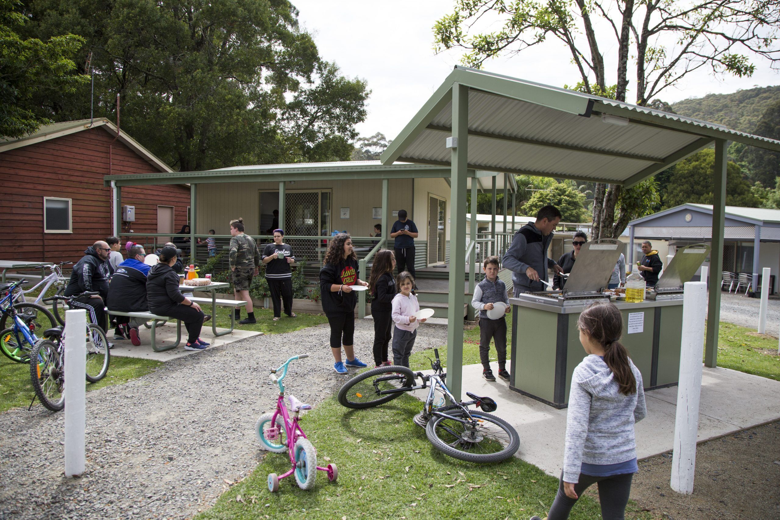 A covered outdoor area with a food service counter, benches, and bicycles.