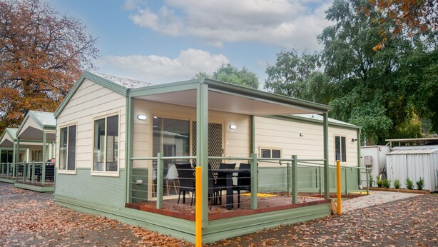 A single-story mobile home with a covered porch and a small patio area. - Warburton Holiday Park (Warburton)