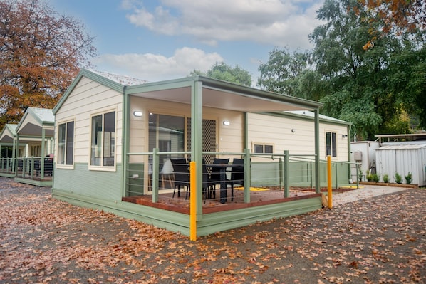 A single-story mobile home with a covered porch and a small patio area.
