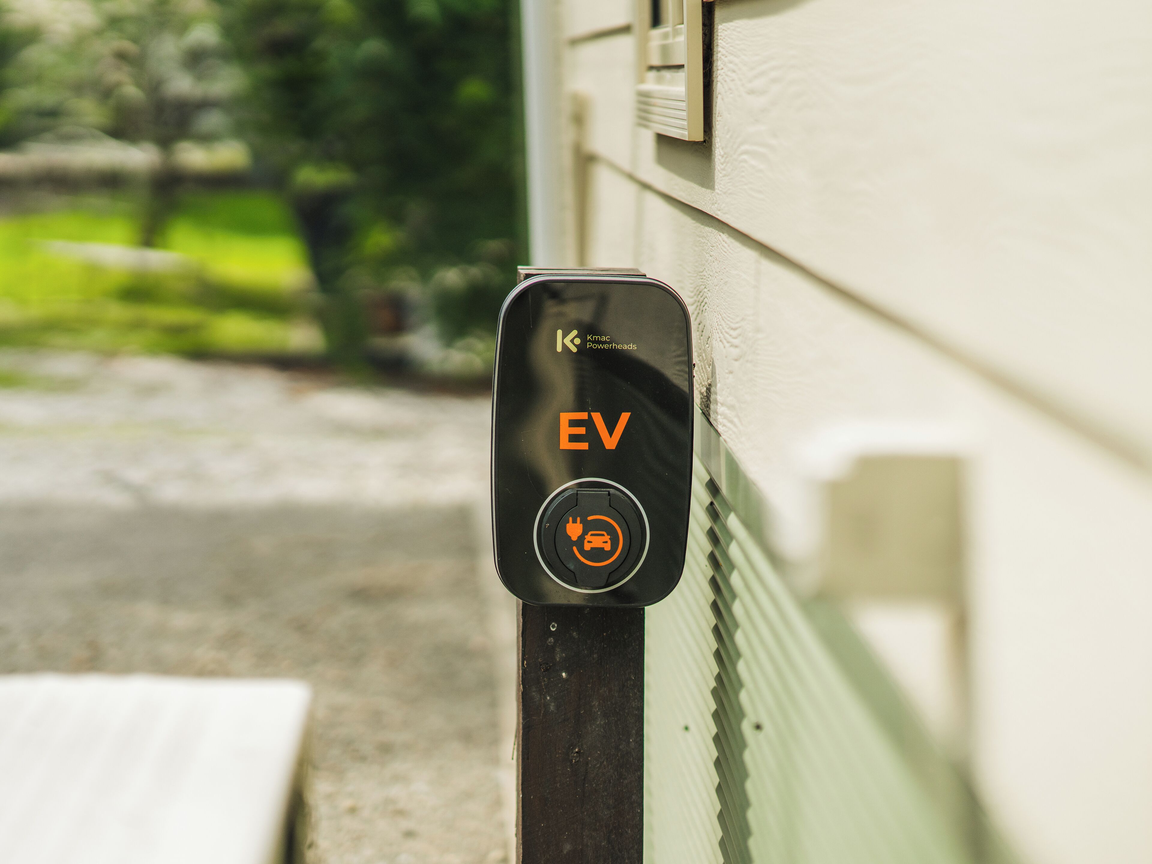 An EV charging station with a clear label and a symbol indicating electric vehicle compatibility.