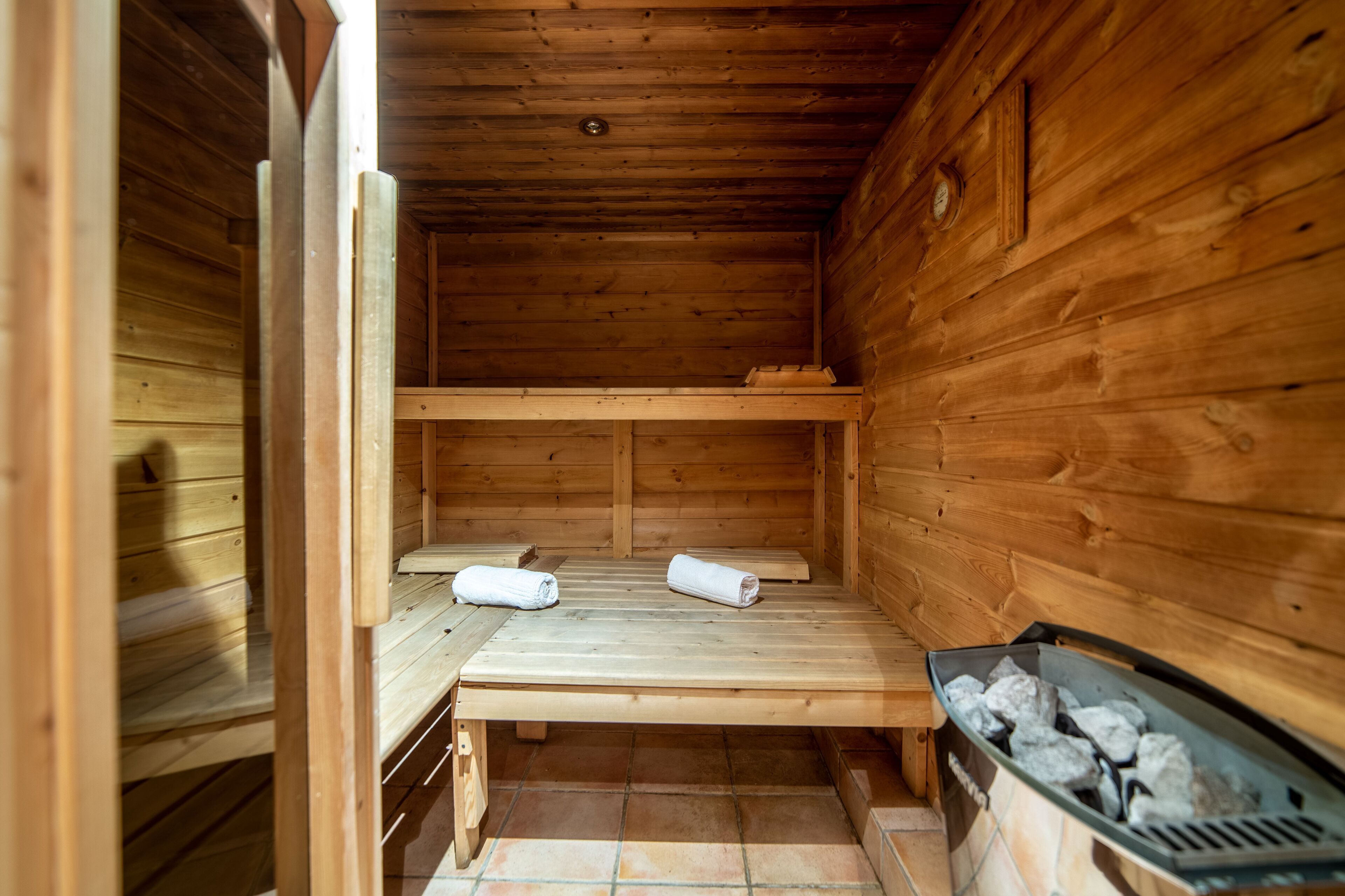 Uma sala de sauna de madeira com bancos e um aquecedor.