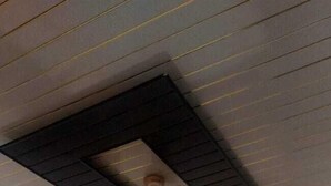 A bedroom with a bed, a ceiling fan, and recessed lighting. - New View Inn (Varanasi)