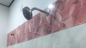A bathroom with a shower and a sink. - New View Inn (Varanasi)