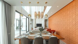 Un comedor moderno con una mesa de madera preparada para seis personas, rodeada de sillas.