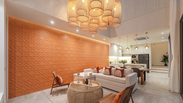 A modern living room with a patterned wall, a round coffee table, and a sofa with orange cushions. - Brand New Top Of The Range Stunning V185 (Choeng Thale)