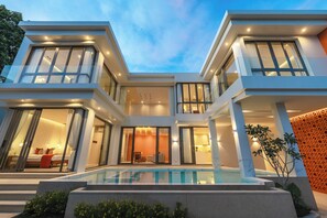 Una moderna casa a più piani con piscina, ampie finestre e interni luminosi.