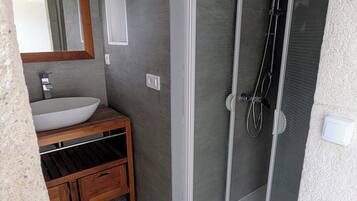 Een douche, handdoeken, zeep, toiletpapier