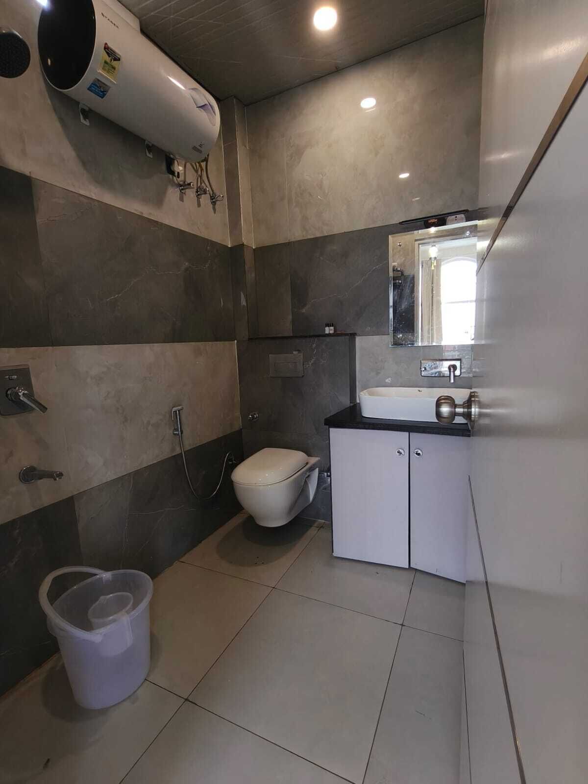 Et moderne badeværelse med toilet, håndvask og brusebad.