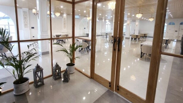 Un interior espacioso y moderno con grandes puertas de cristal que dan a un comedor.