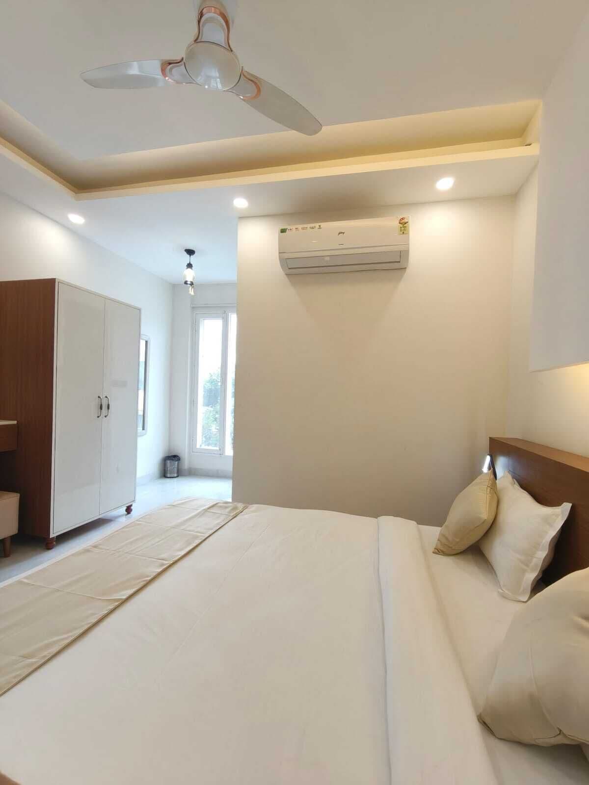 Un dormitorio con cama, armario, ventilador de techo, aire acondicionado y ventana.