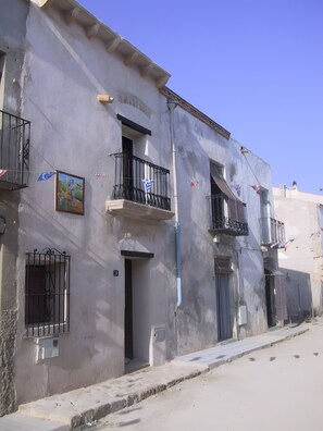 A building with balconies, a door, and a window with a metal gate. - Casa Bohemio - Tabarca (Tabarca)