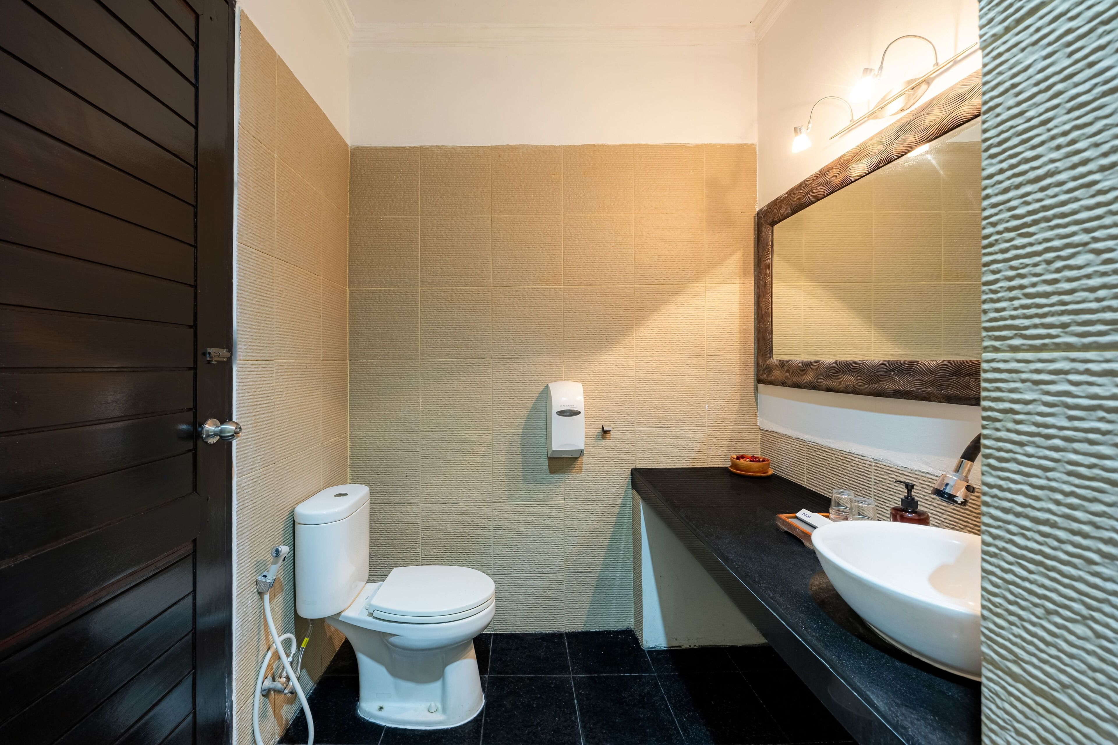 A bathroom with a toilet, sink, and mirror.