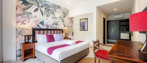 Une chambre d’hôtel avec un lit, une table de chevet, un bureau et une chaise.