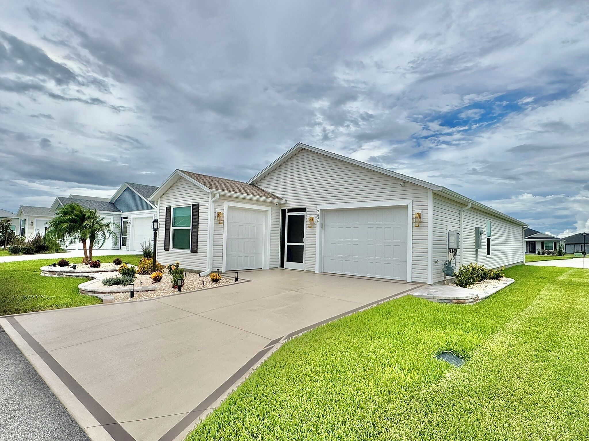 A single-story residential house with a front garage, a driveway, and a well-maintained lawn.