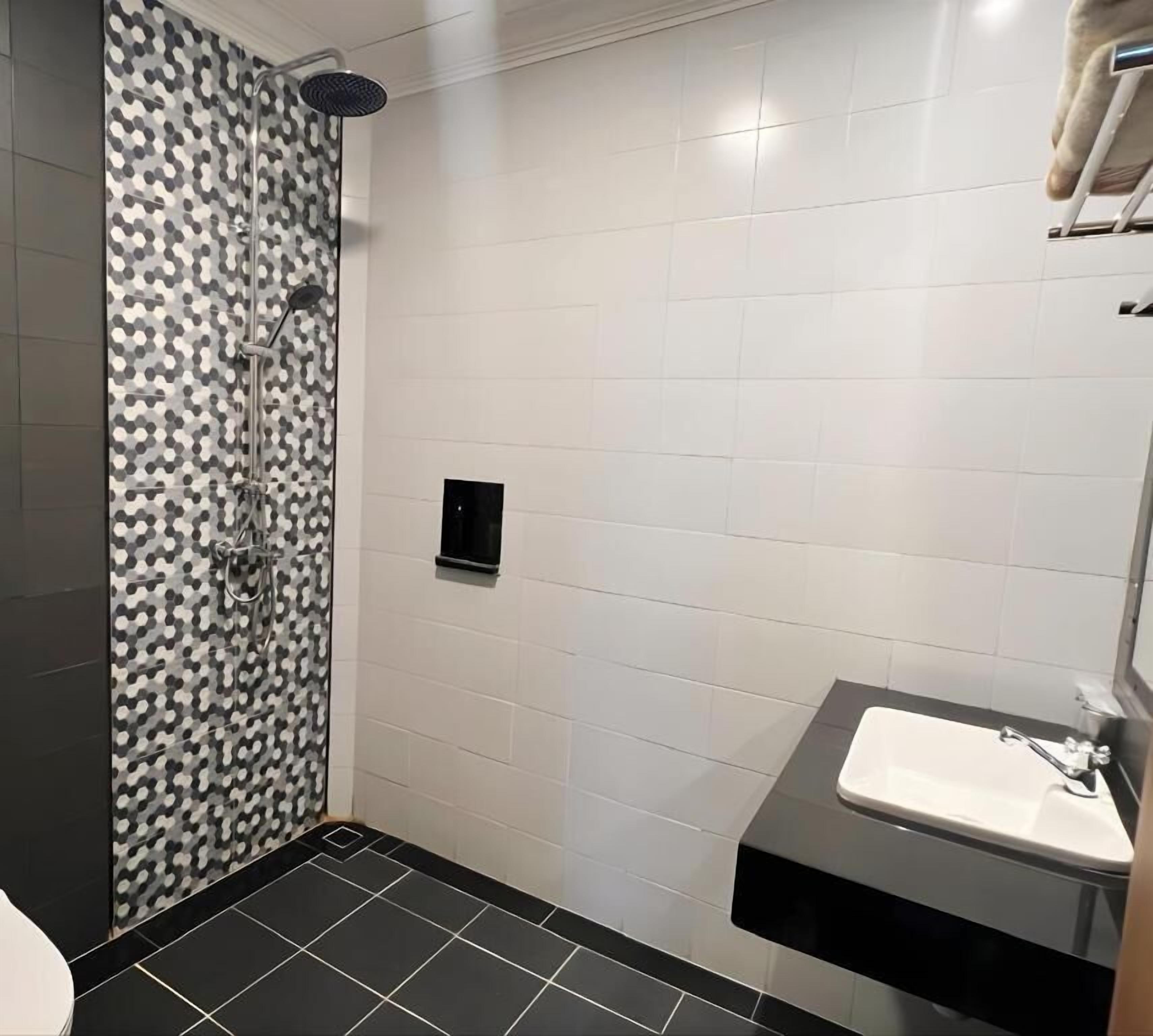 A bathroom with a shower, a toilet, and a sink.