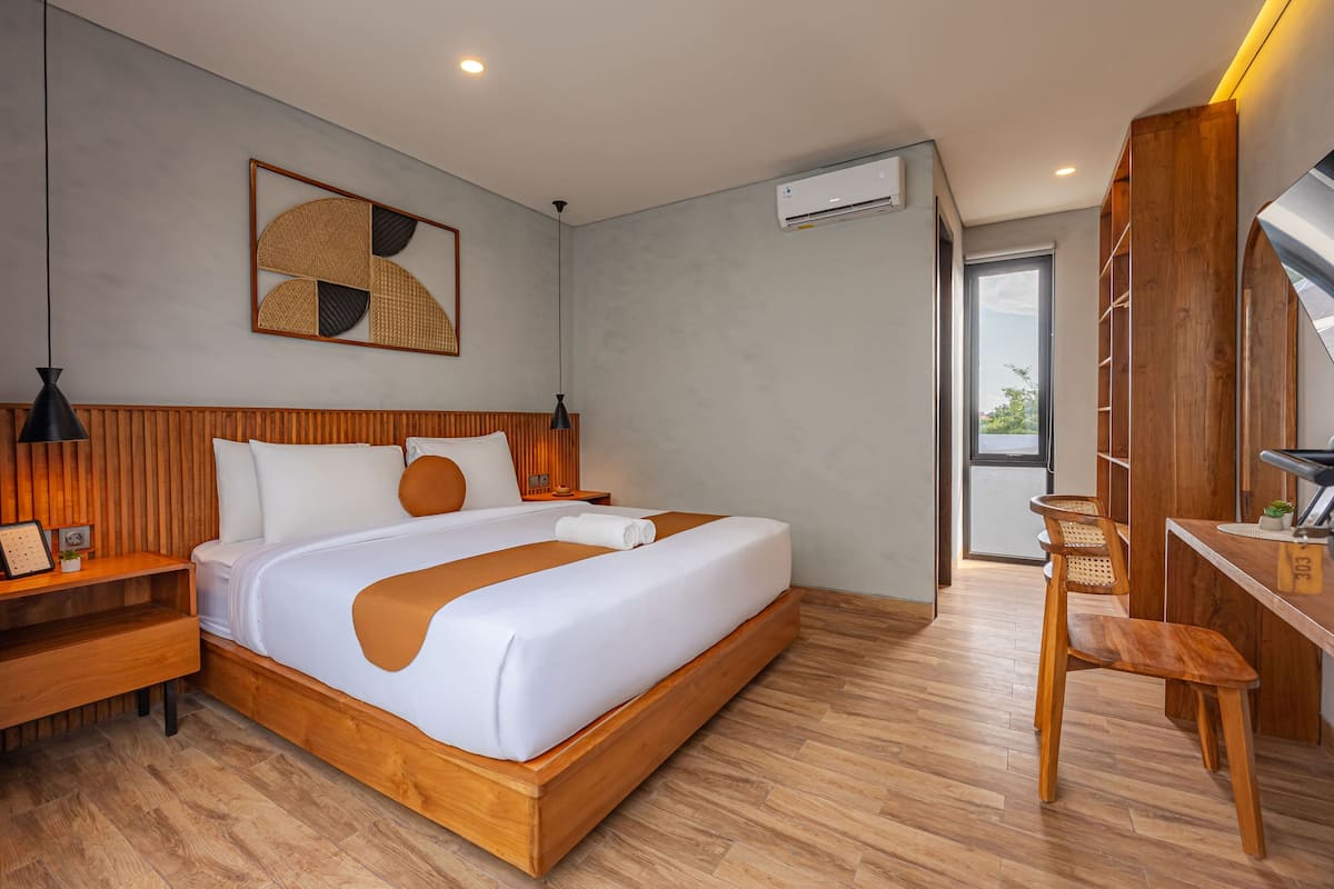Una habitación de hotel moderna con una cama de madera, un escritorio y una silla.