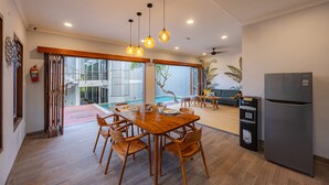 Una cocina moderna con comedor, suelo de madera y refrigerador.