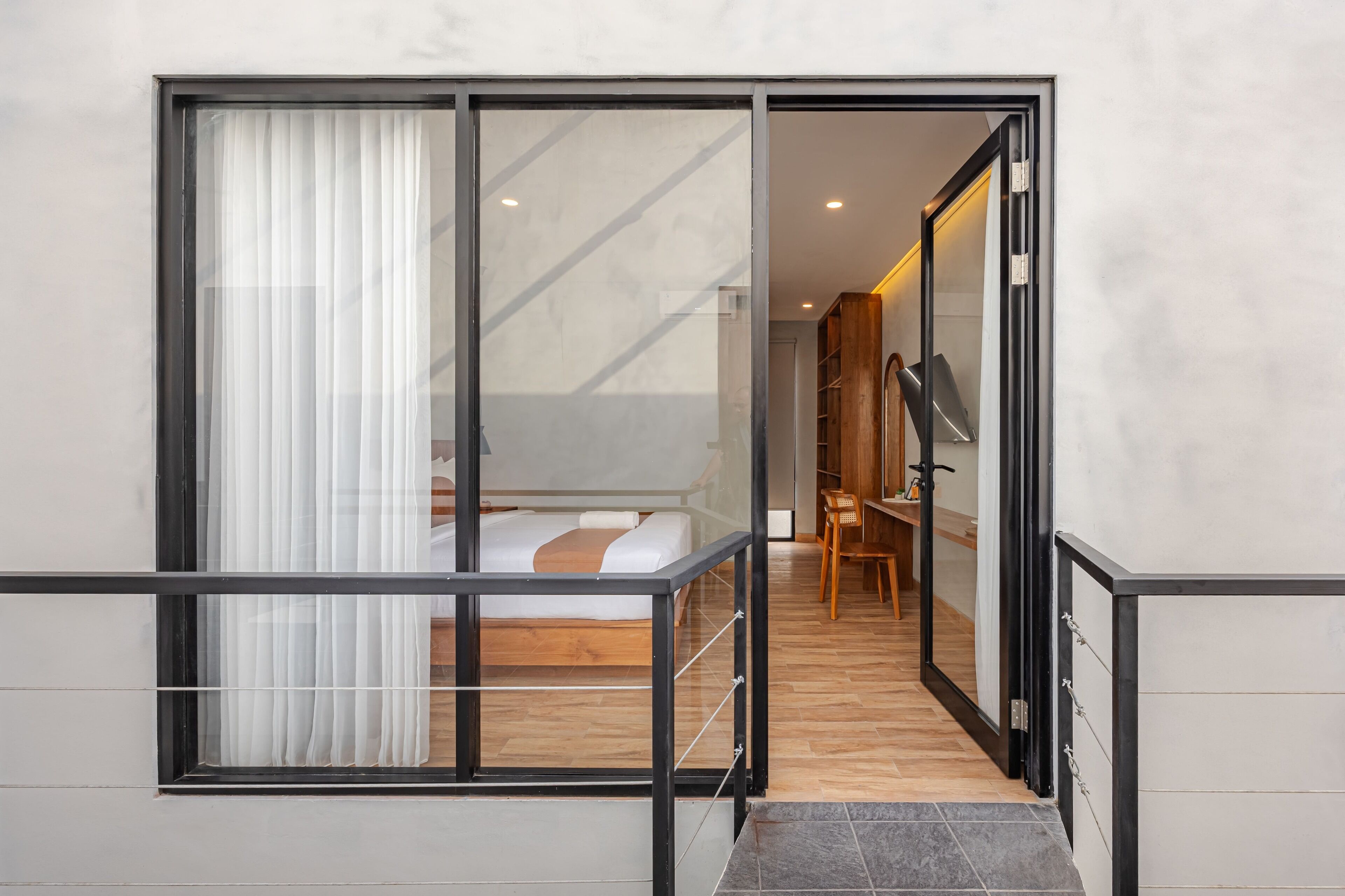 A modern bedroom with a large sliding glass door leading to a balcony.