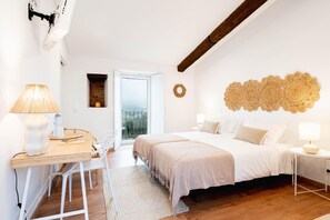 A bedroom with a bed, bedside tables, a desk, and a chair.