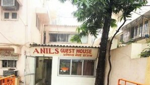 Ein Gästehaus namens „ANIL'S GUEST HOUSE“ mit gefliestem Eingangsbereich und einem kleinen Garten.