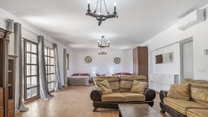 Un salón amplio con un sofá grande, una mesa de centro y una araña.