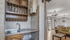 Una cocina con un fregadero, armarios de madera y un cubo de basura.