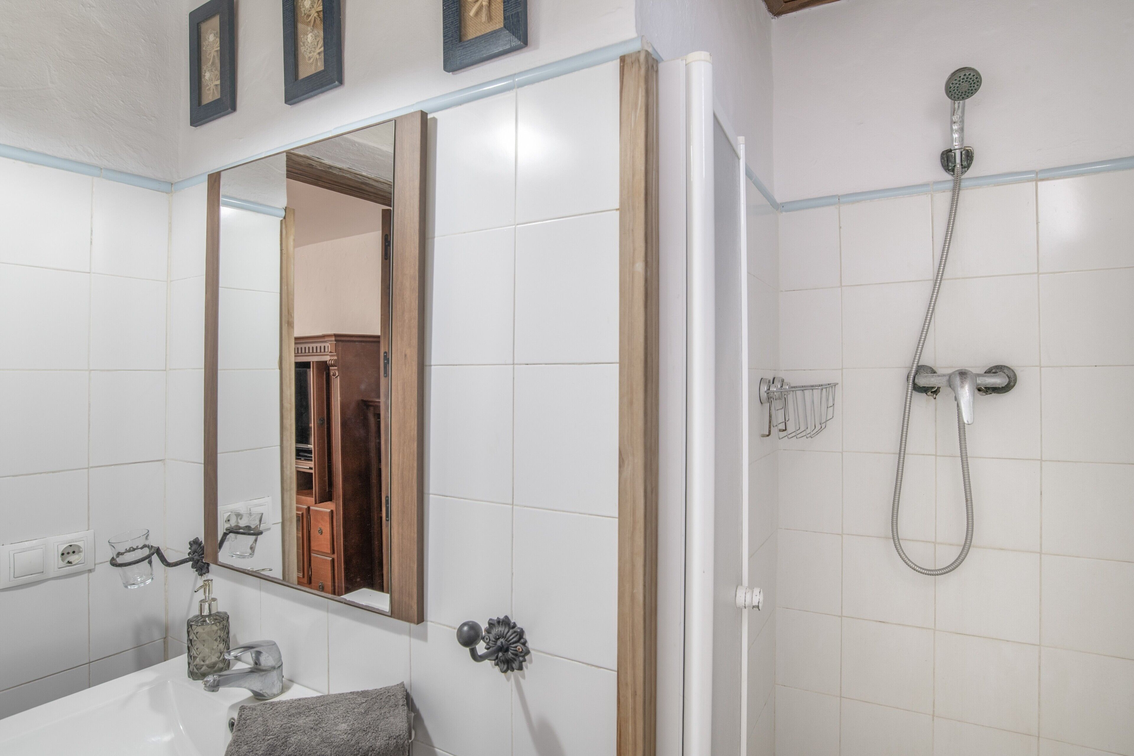 A bathroom with a white sink, mirror, and shower.