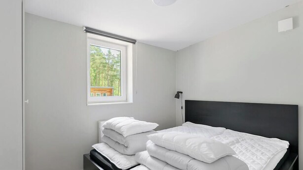 A bedroom with a bed, a window, and a nightstand. - First Camp Skara - Sommarland (Axvall)