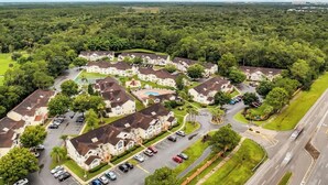 A residential area with multiple houses, a swimming pool, and a road. - Quiet 3BR retreat - pool, gym & Disney close (Kissimmee)