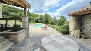 A covered patio with a pool, stone steps, and a table with chairs. - Charming stone cottage with heated pool, pets welcome near Périgueux (Coulounieix-Chamiers)