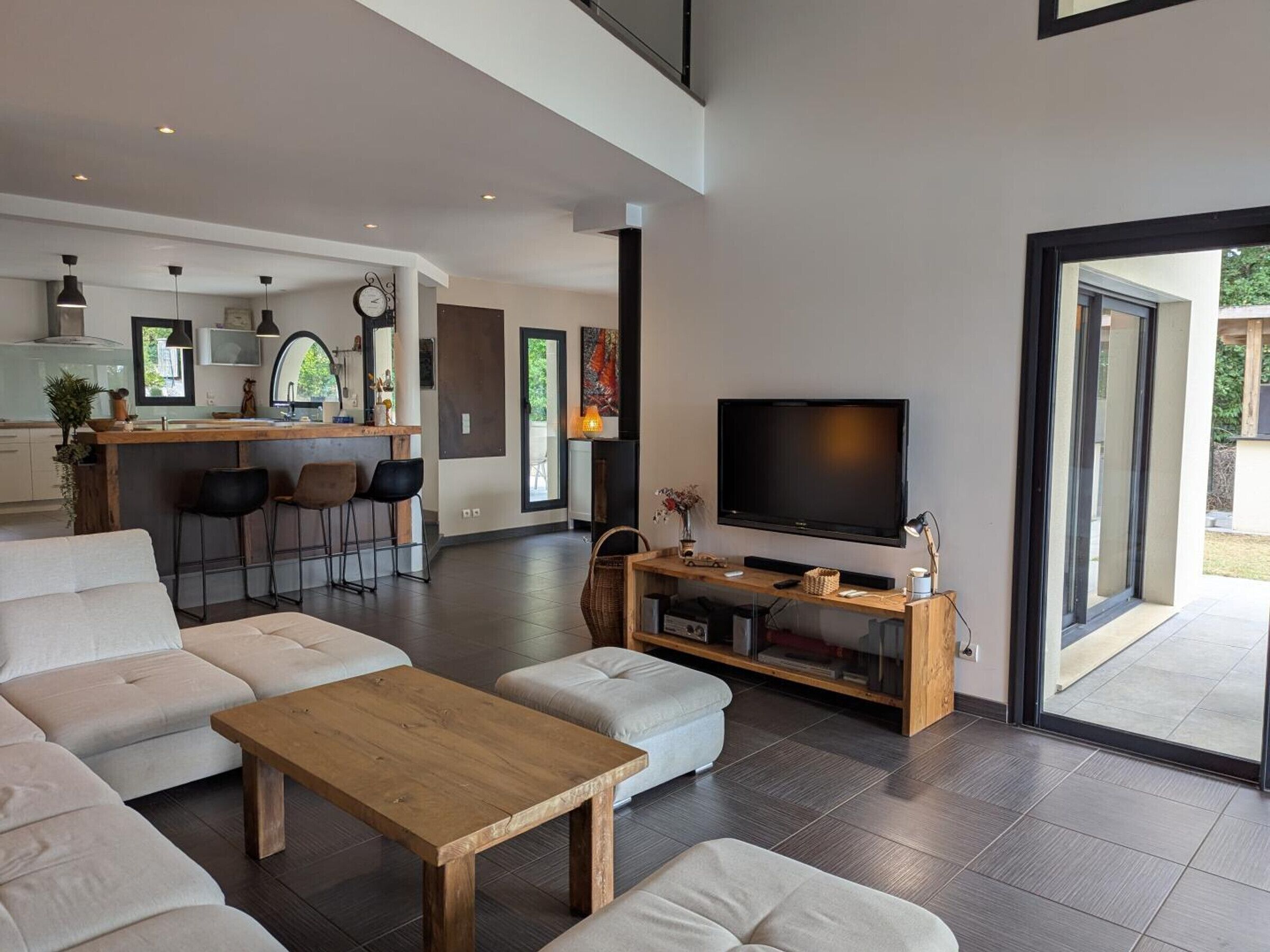 A modern living room with a large TV, a wooden coffee table, and a sofa.
