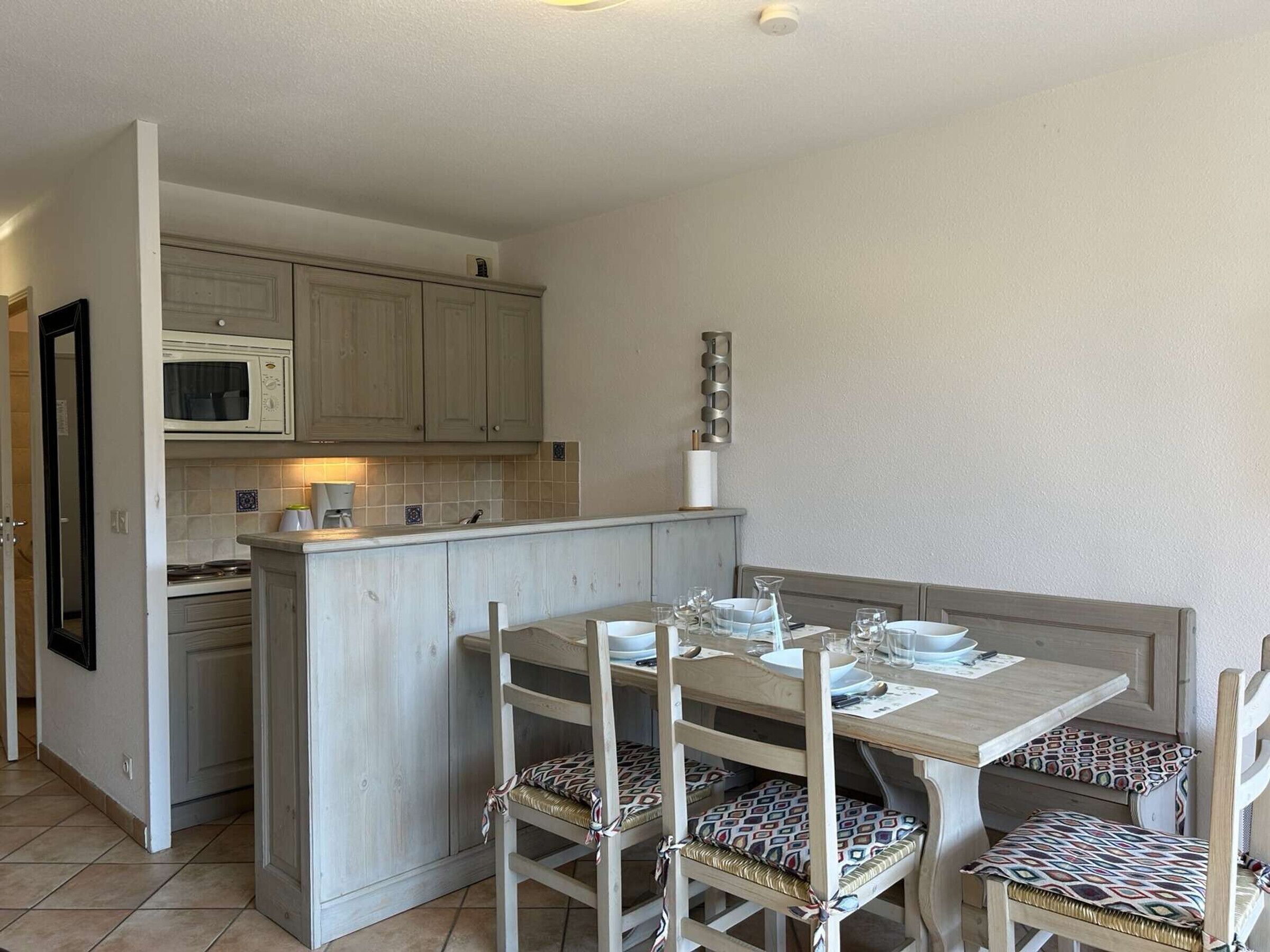 A compact kitchen with a microwave, a stove, and a small island with seating.