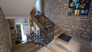 A staircase with stone walls and a metal railing.