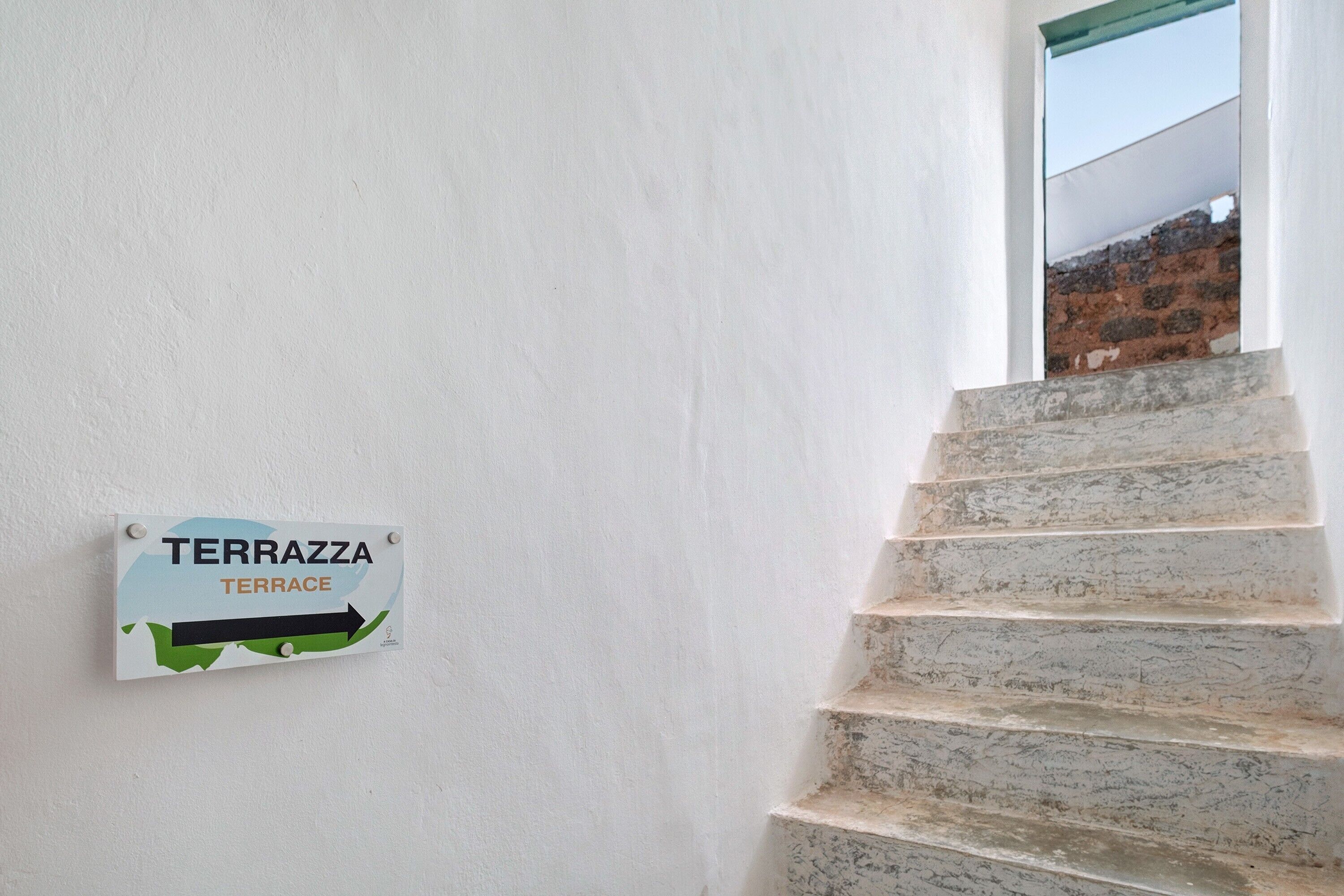 A sign for 'TERRAZZA' with an arrow pointing to the right, indicating a direction.