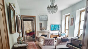 A spacious living room with a fireplace, a grand piano, and a red carpet leading to a dining area. - villa raspail (Ivry-sur-Seine)