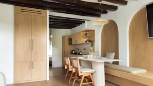 Eine moderne Küche mit Holzausstattung, einer zentralen Kochinsel mit Sitzgelegenheiten und einer hängenden Leuchte.