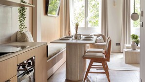 Eine moderne Küche mit Holzschränken, einem eingebauten Backofen und einer zentralen Kochinsel mit Sitzgelegenheit.