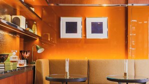 A cozy lounge area with a sofa, two small tables, and a ceiling light fixture. - Confidential Room 5, a Stone's Throw From the Louvre (Paris)