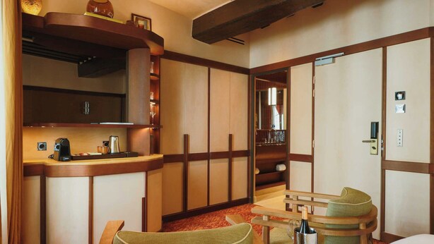 A hotel room with a traditional Japanese-style interior, including tatami mats, a low wooden desk, a green cushioned chair, and a large mirror. - Confidential Room 5, a Stone's Throw From the Louvre (Paris)
