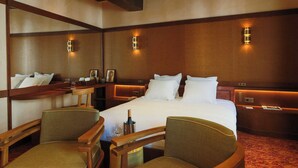 A hotel room with a large bed, two bedside tables, a mirror, and two armchairs. - Confidential Room 5, a Stone's Throw From the Louvre (Paris)