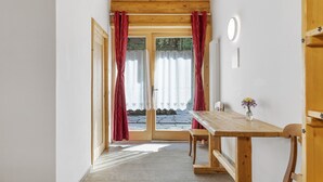 A wooden-framed room with a bench, a table, and a view through a glass door. - 'Genziana' Room with Mountain View, Private Terrace and Wi-Fi (Cogolo di Peio)